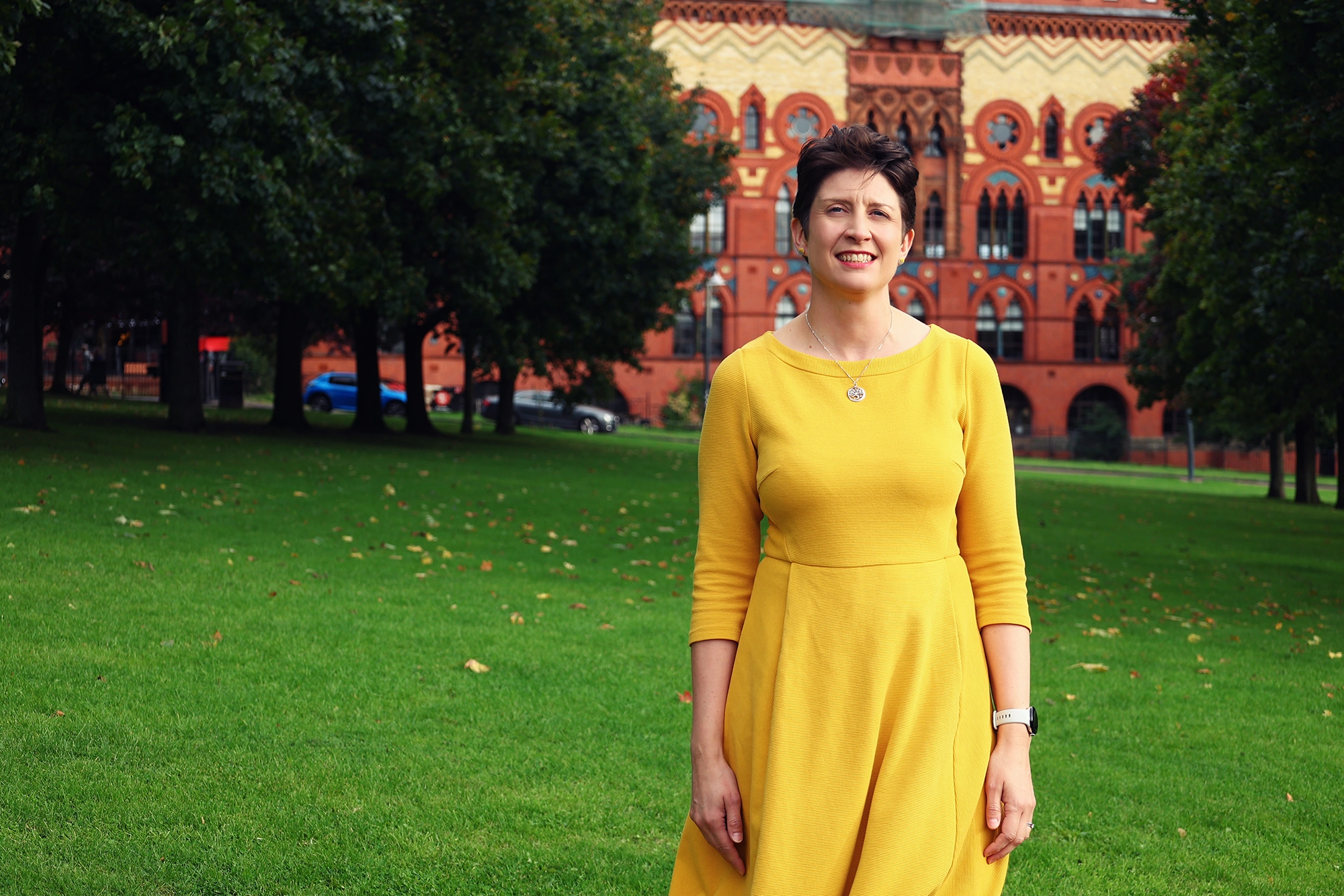 Alison Thewliss standing in Glasgow Green, with the former Templeton Carpet Factory behind her.
